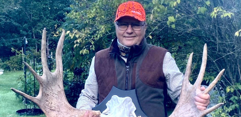 Bild på Mats när han håller upp horn ute i naturen