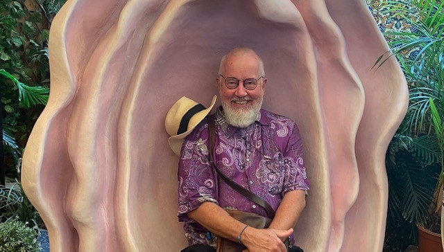 Glad bild på Per sittandes i en blomma 