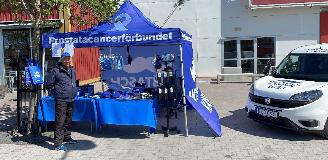 Håkan Florin står framför förbundets tält och Mustaschkampen-bilen