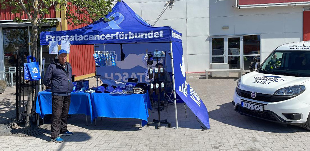 Håkan Florin står framför förbundets tält och Mustaschkampen-bilen