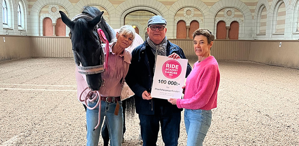 Man tar emot en check från två kvinnor som står tillsammans med en häst