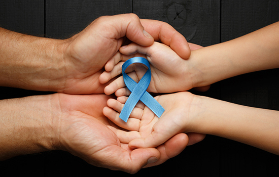 Ett par vuxna händer och ett par barnhänder med öppna handflator som håller i ett blått satinband