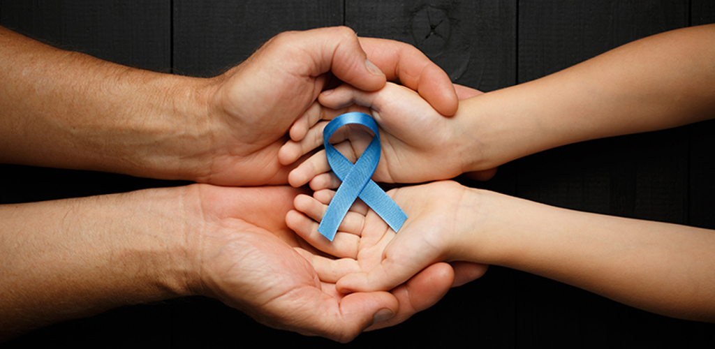 Ett par vuxna händer och ett par barnhänder med öppna handflator som håller i ett blått satinband