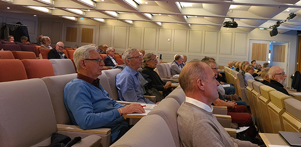 Män och kvinnor sitter i en stor konferenslokal