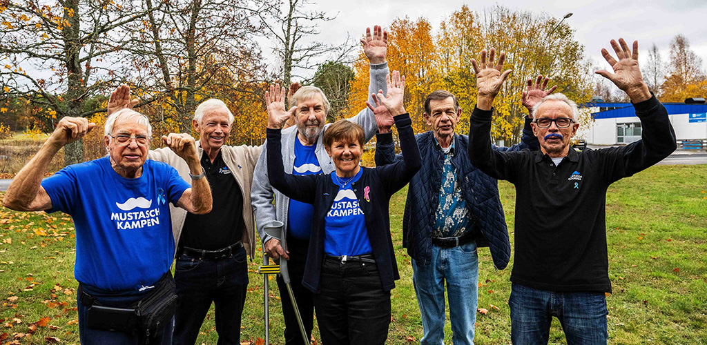 Grupp glada äldre personer som håller armarna upp i skyn