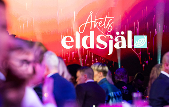 Logga för Årets eldsjäl i fokus med sittande gäster vid en middag i förgrunden