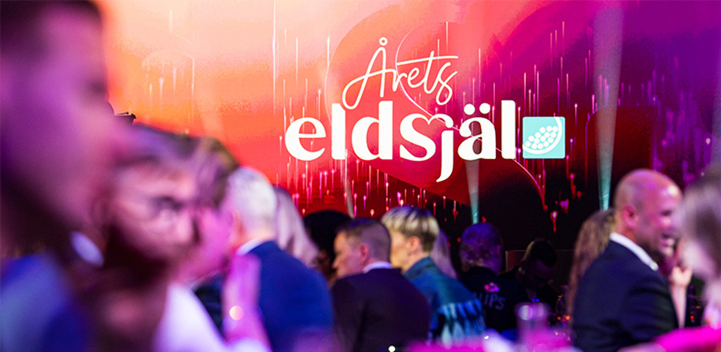 Logga för Årets eldsjäl i fokus med sittande gäster vid en middag i förgrunden