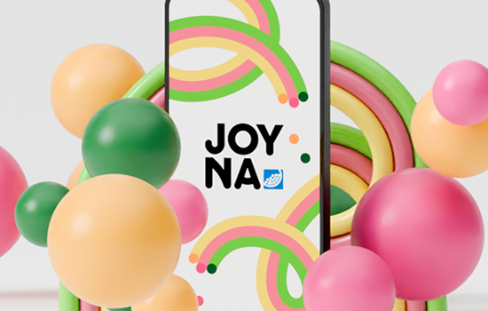 Smartphone som visar JOYNA s logotyp omringad med färgade bollar