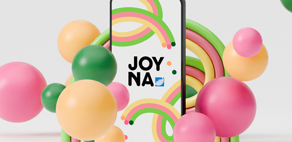 Smartphone som visar JOYNA s logotyp omringad med färgade bollar