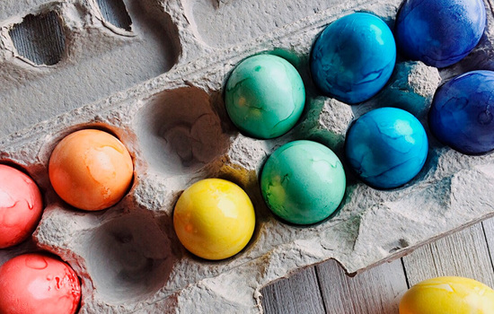 Färgglada målade påskägg i en äggkartong