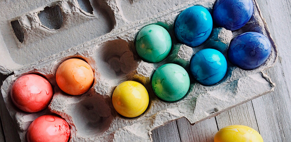 Färgglada målade påskägg i en äggkartong
