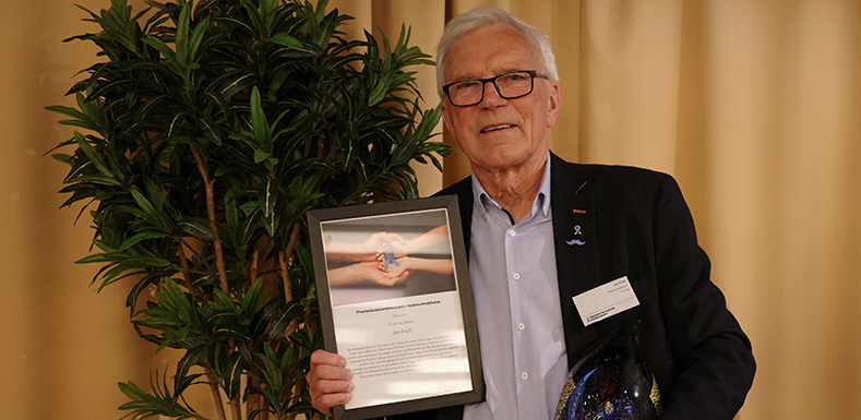 Jan Frick visar upp diplomet och skulpturen i glas han fick som mottagare av Prostatacancerförbundets hedersutmärkelse.