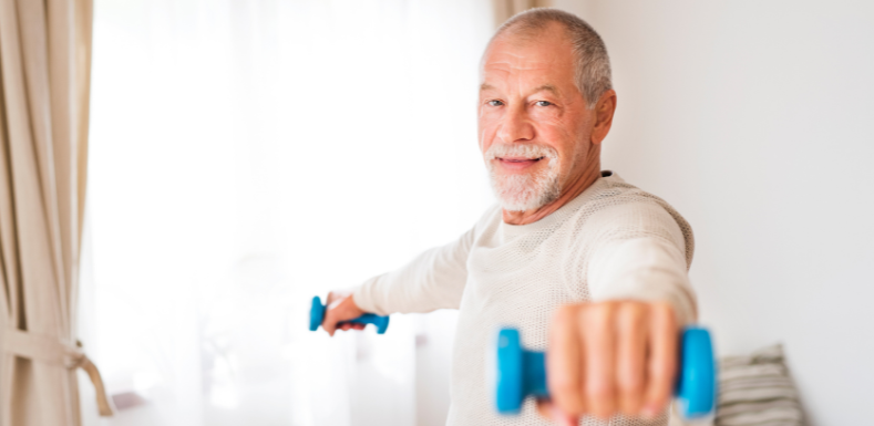 Äldre man tränar med hantlar i bägge händerna