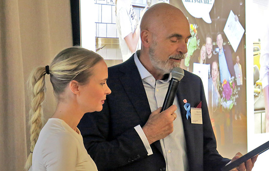 En kvinna och en man står och läser texten på ett diplom 