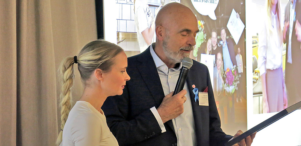 En kvinna och en man står och läser texten på ett diplom 